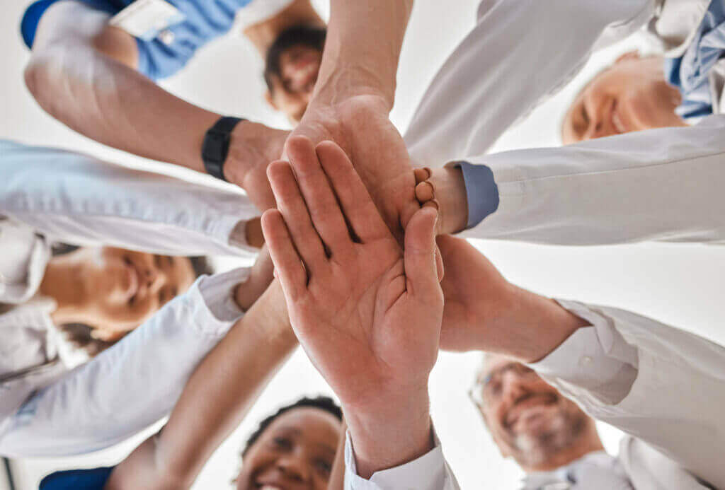 Medical team stacking hands together